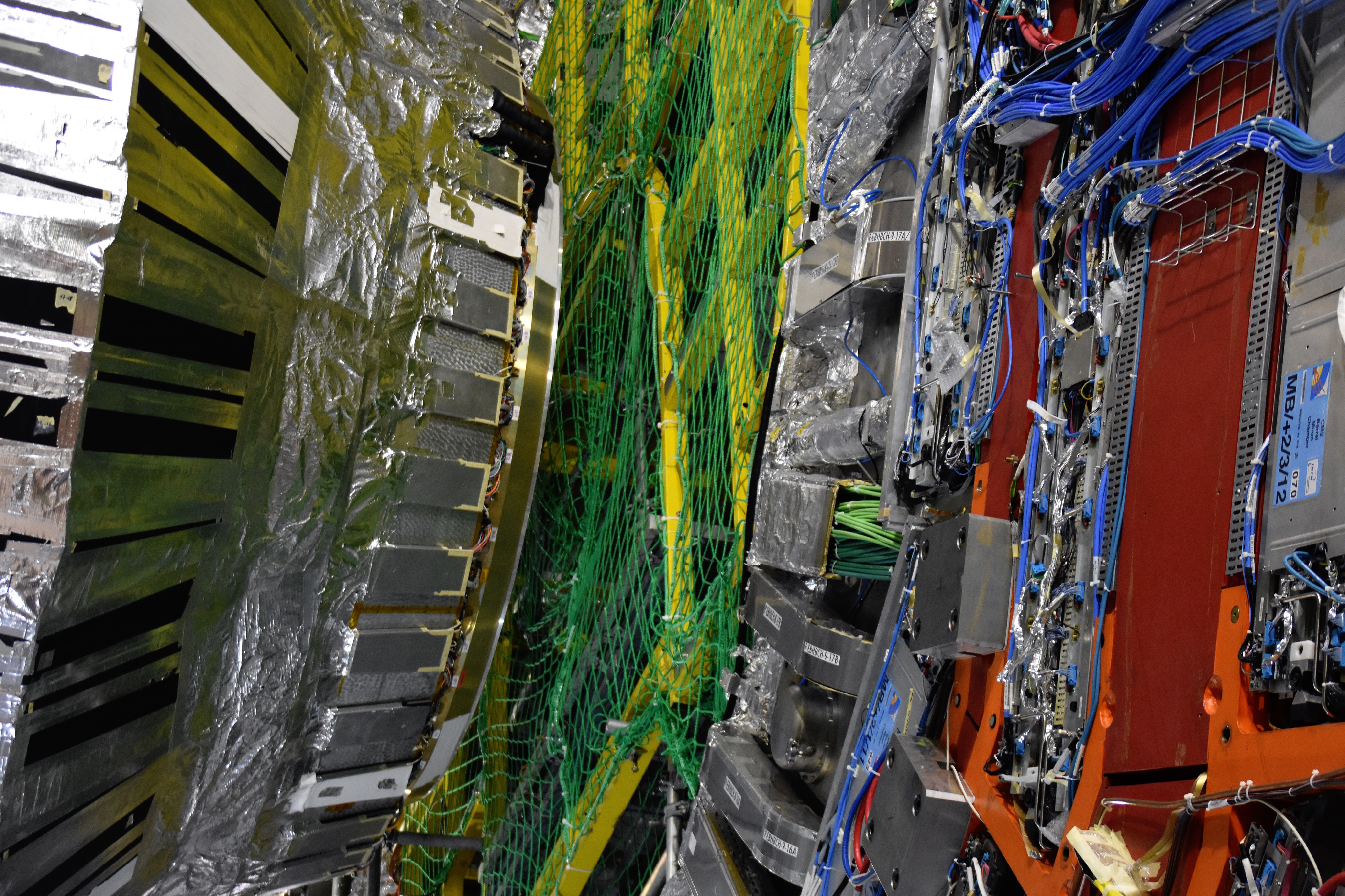 Metal detector components, green cabling and blue wires inside CERN’s CMS experiment.