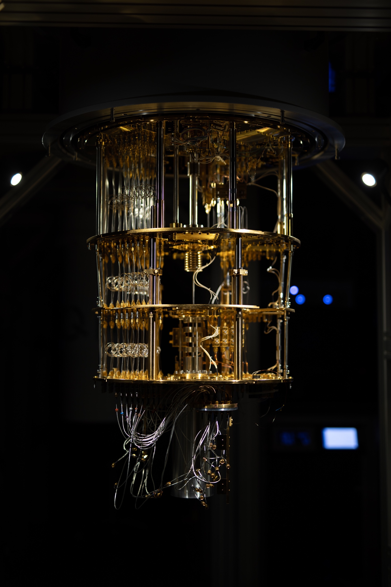 Exposed gold-colored stages, wiring and supports of an IQM quantum computer in Espoo.